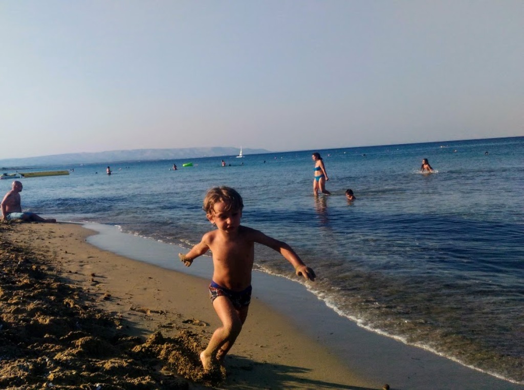 bambino che corre sulla spiaggia durante un weekend al mare in sicilia