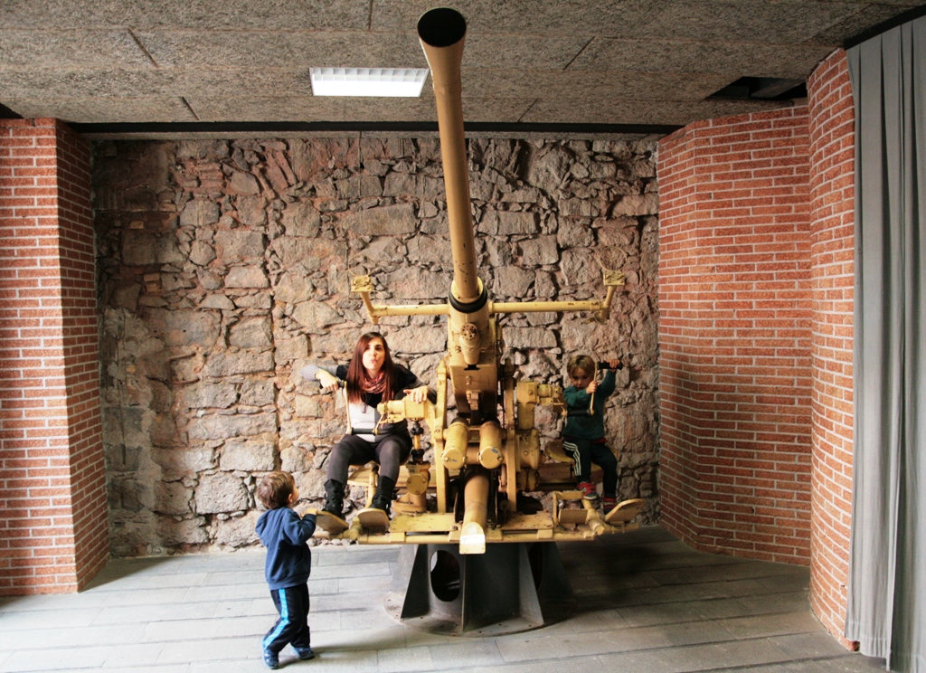 mamma e figli che giocano su un cannone contraereo al museo dello sbarco in sicilia