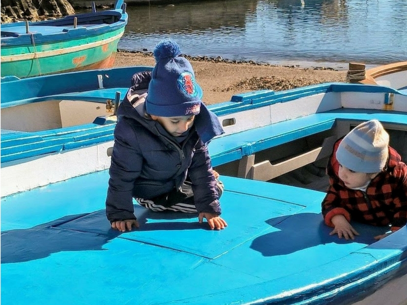 bambini su un'imbarcazione di Aci Trezza