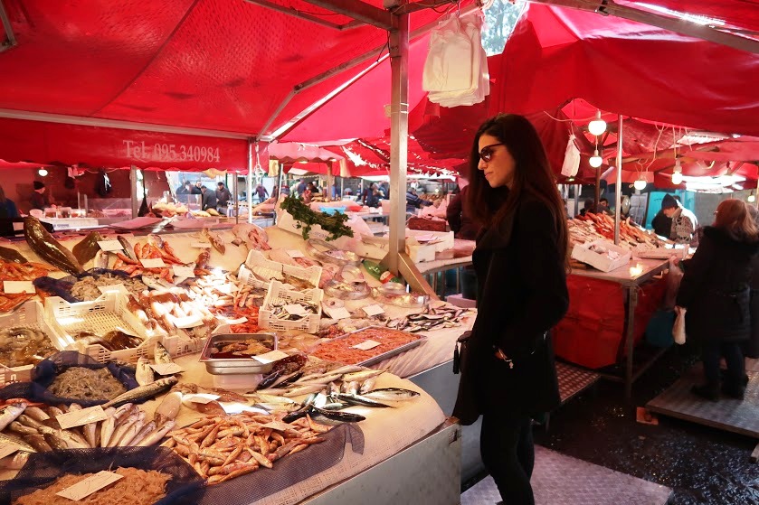 una ragazza al mercato del pesce di catania durante uno street food tour