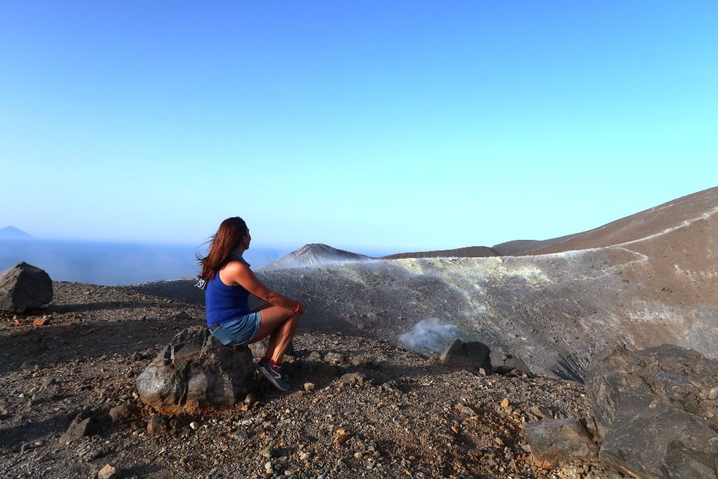 donna che guarda il gran cratere di vulcano