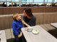 una mamma e un bambino seduti alla Plaza Premium Lounge di Fiumicino
